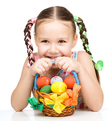 Image showing Little girl with basket full of colorful eggs