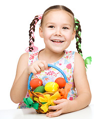 Image showing Little girl with basket full of colorful eggs