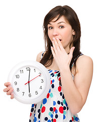 Image showing Young woman is holding big clock