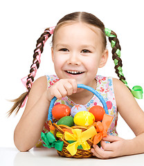 Image showing Little girl with basket full of colorful eggs