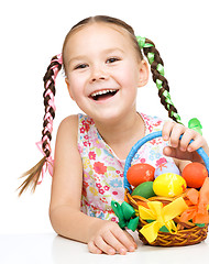 Image showing Little girl with basket full of colorful eggs