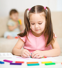 Image showing Little girl is playing with plasticine