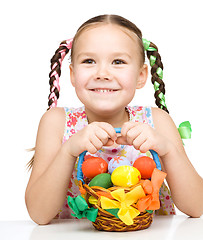 Image showing Little girl with basket full of colorful eggs