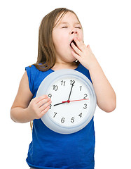 Image showing Little girl is holding big clock