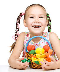 Image showing Little girl with basket full of colorful eggs