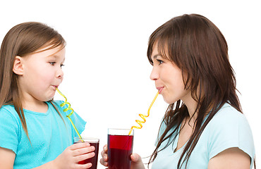 Image showing Mother and her daughter are drinking juice