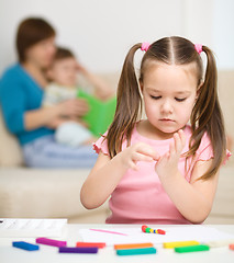 Image showing Little girl is playing with plasticine