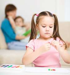 Image showing Little girl is playing with plasticine