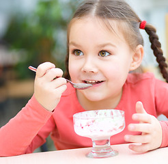 Image showing Little girl is eating ice-cream in parlor