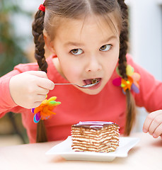 Image showing Little girl is eating cake in parlor