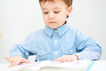 Image showing Little boy is reading book