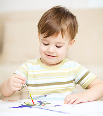 Image showing Little boy is playing with paints