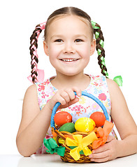 Image showing Little girl with basket full of colorful eggs