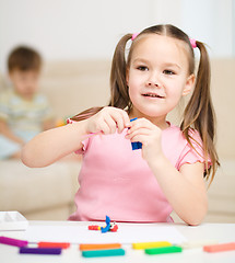 Image showing Little girl is playing with plasticine