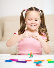 Image showing Little girl is playing with plasticine