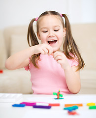 Image showing Little girl is playing with plasticine