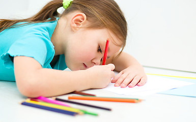 Image showing Little girl is drawing using pencils