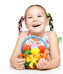 Image showing Little girl with basket full of colorful eggs