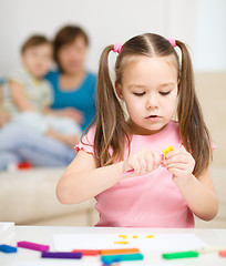 Image showing Little girl is playing with plasticine