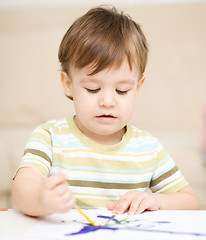 Image showing Little boy is playing with paints