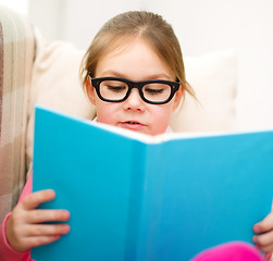 Image showing Little girl is reading a book