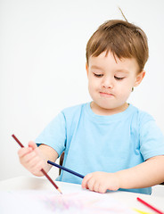 Image showing Little boy is drawing on white paper