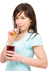 Image showing Young woman is drinking cherry juice