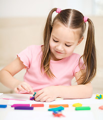 Image showing Little girl is playing with plasticine