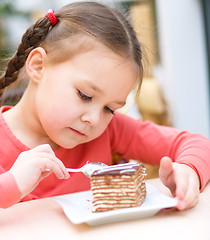 Image showing Little girl is eating cake in parlor