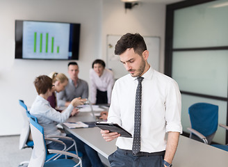 Image showing young business man with tablet at office meeting room