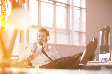 Image showing relaxed young businessman first at workplace at early morning