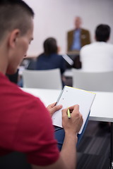 Image showing male student taking notes in classroom