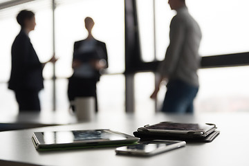 Image showing close up of tablet, business people on meeting in background