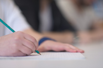 Image showing male student taking notes in classroom