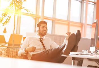 Image showing relaxed young businessman first at workplace at early morning