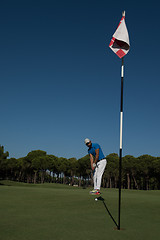 Image showing golf player hitting shot at sunny day