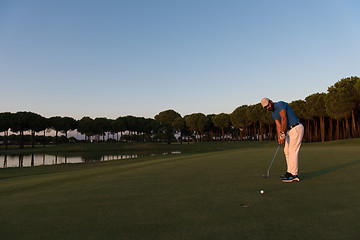 Image showing golfer  hitting shot at golf course