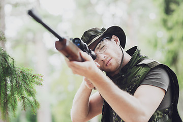 Image showing young soldier or hunter with gun in forest