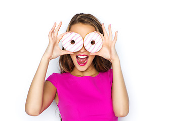 Image showing happy woman or teen girl looking through donuts