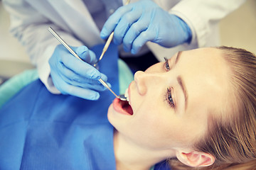 Image showing close up of dentist checking female patient teeth