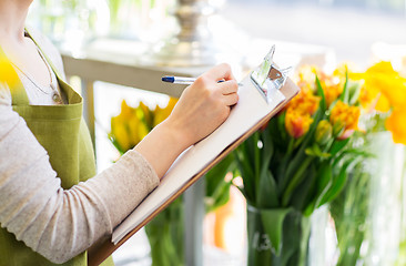 Image showing close up of woman with clipboard at flower shop