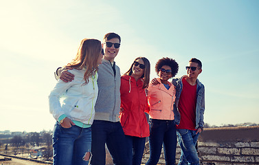 Image showing happy teenage friends walking along city street