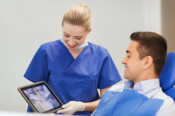 Image showing dentist with x-ray on tablet pc and male patient