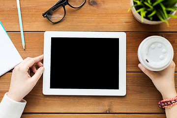 Image showing close up of woman with tablet pc on wooden table