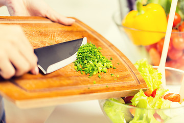 Image showing close up of woman with chopped onion cooking salad