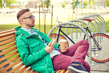 Image showing happy young hipster man with coffee and sandwich