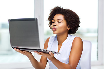 Image showing african woman sending kiss to laptop computer