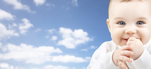 Image showing happy baby face over blue sky background