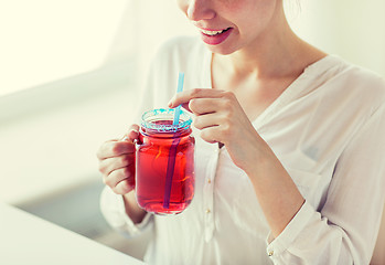 Image showing woman drinking juice from glass mug with straw