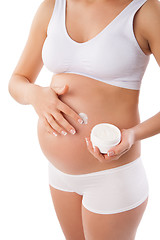 Image showing Pregnant woman with cosmetic cream on belly